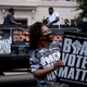 Demonstrators hold up signs during a live performance by the organization Long Live GoGo at a voting rights protest outside the U.S. Chamber of Commerce Headquarters on August 26, 2021, in Washington, DC.